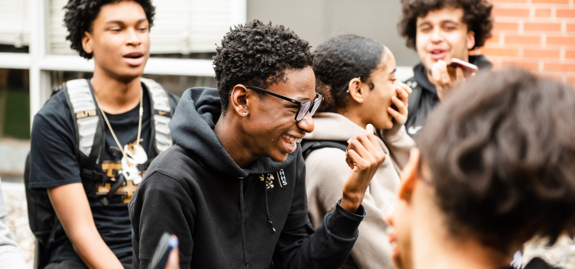 Teens laughing outside school